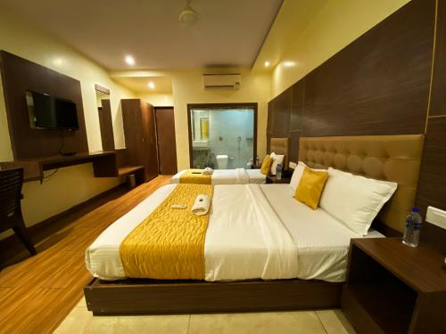 a hotel room with a large bed and a television at Hotel Pearl's BKC Inn- Near Trade Centre, Visa Consulate in Mumbai