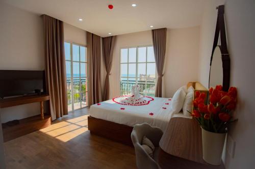 um quarto com uma cama com um vaso de flores em Hotel Kim Thái em Phu Quoc