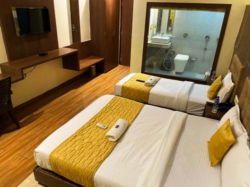 a hotel room with two beds and a bathroom at Hotel Pearl's BKC Inn- Near Trade Centre, Visa Consulate in Mumbai