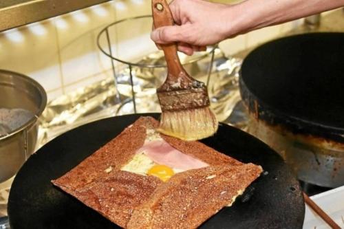 a person is brushing toast with a spatula at Ker Tornaod Maison familiale avec accès direct à la mer in Guimaëc