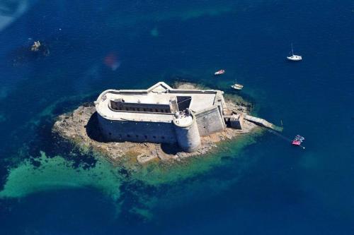 an island in the middle of the water with boats at Ker Tornaod Maison familiale avec accès direct à la mer in Guimaëc