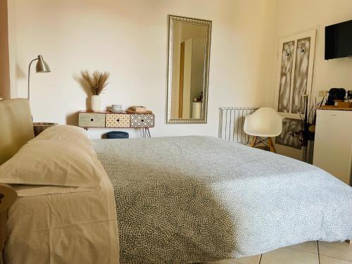 a bedroom with a large bed and a mirror at B&B L'albero di Melograno in Seccheto