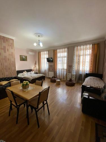 a living room with a table and chairs at Guest house Lusia in Tbilisi City