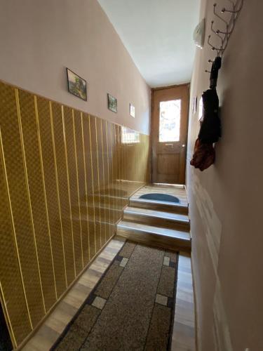 a hallway with yellow walls and stairs with a door at Guest house Lusia in Tbilisi City