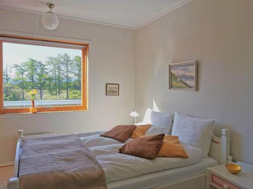 1 dormitorio con cama con almohadas y ventana en Vigra vintage en Vigra