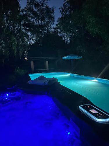una piscina por la noche con luces azules en Willa 250 M z basenem, jacuzzi, ogrodem , tarasem oraz 2 hektary sadu , kominek i inne atrakcje 