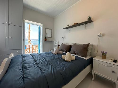 Un dormitorio con una gran cama azul y una ventana en Brinia Cosy Apartment, en Poros