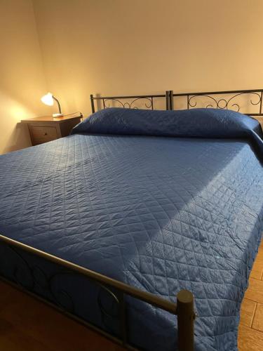 un letto con una coperta blu sopra di Casa Vacanza Le Cinque Perle a Francavilla Fontana