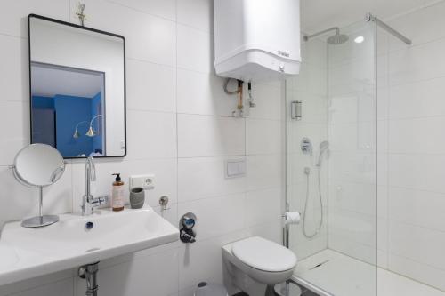 a white bathroom with a toilet and a shower at Arbio I Central Apartments Koblenz in Koblenz