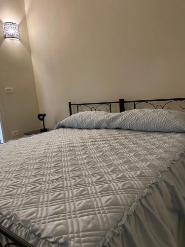 1 cama con edredón blanco en un dormitorio en Le cinque perle, en Francavilla Fontana