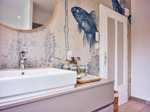 a bathroom with a sink and a fish painting on the wall at Top Ferienhaus bei Spitz / Wachau in Schwallenbach