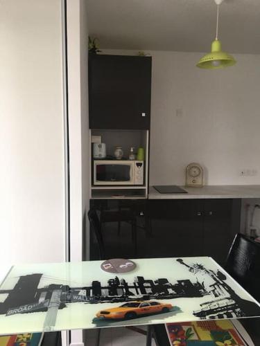 une cuisine avec une table et un comptoir dans l'établissement Appartement neuf pontaillac, à Royan