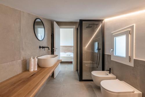 ein Badezimmer mit einer Badewanne, einem Waschbecken und einem WC in der Unterkunft Villa alla Baia dei Sette Emiri by Wonderful Italy in Cefalú