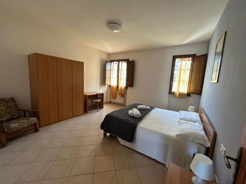 1 dormitorio con 1 cama y 1 silla en Residence San Francesco, en Pomarance