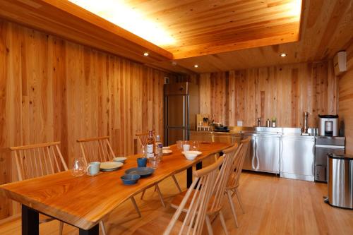 a dining room with a wooden table and chairs at Kisara Oneness in Toba