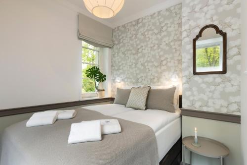 a bedroom with a bed with towels on it at Willa Szwarc by Elite Apartments in Sopot
