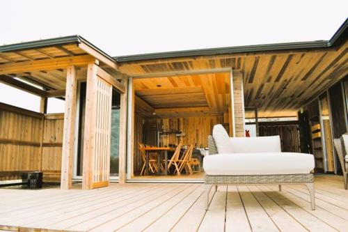 a white couch sitting on a wooden deck at Kisara Oneness in Toba