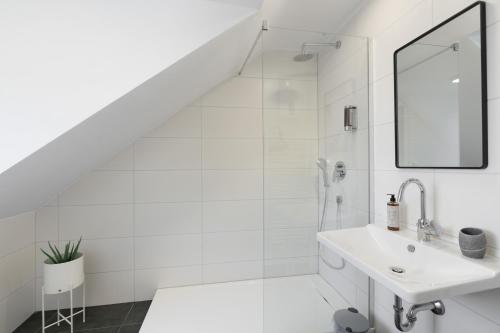 a white bathroom with a sink and a mirror at Arbio I Central Apartments Koblenz in Koblenz