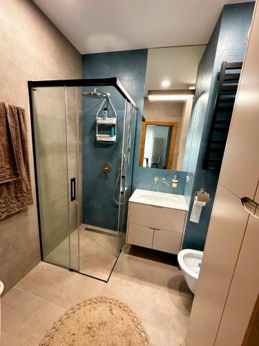 a bathroom with a shower and a toilet and a sink at Apartament VIP Wola in Warsaw