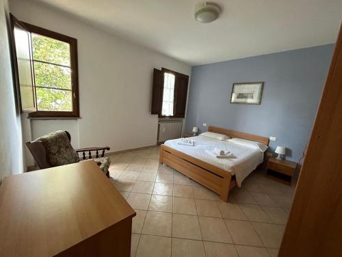 um quarto com uma cama, uma cadeira e uma mesa em Residence San Francesco em Pomarance