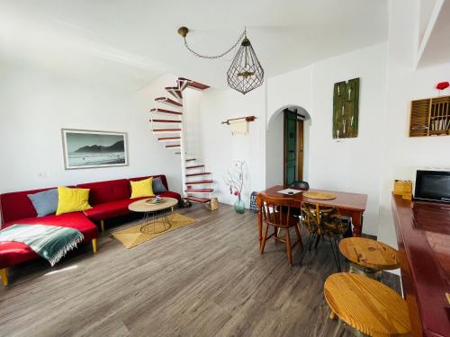 un soggiorno con divano rosso e tavolo di Casa Pura Vida y el Mar a Caleta de Caballo