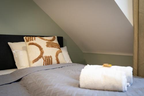 a bedroom with a bed with a white blanket and pillows at Arbio I Central Apartments Koblenz in Koblenz