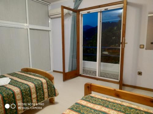 a room with two beds and a large window at Muses apartments in Eretria