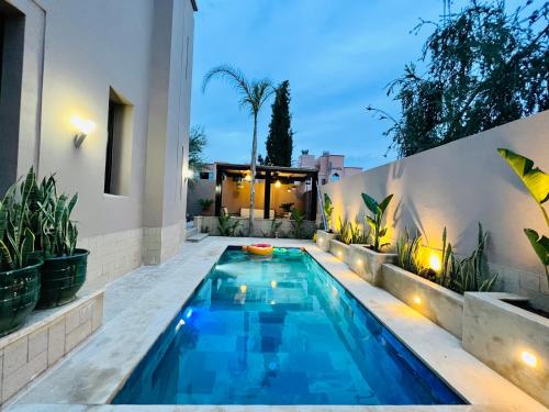 uma piscina no quintal de uma casa com plantas em SABOR VILLA TARGA GARDEN -Only Family em Marraquexe