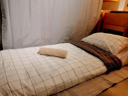 a bed with a towel on top of it at HomeBase Apartment Hotel in Manila