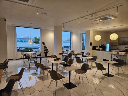 a restaurant with tables and chairs in a room at Hotel Haemaru in Gwangyang