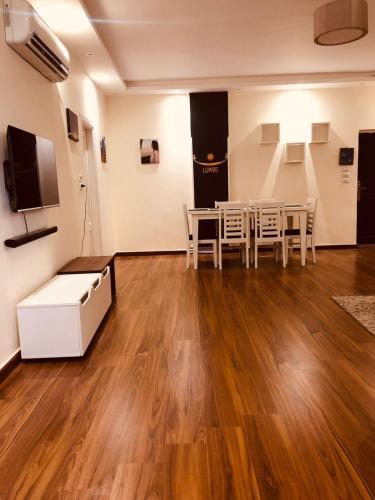 a room with a table and chairs and a tv at Sphinx Luxor Apartment in Luxor