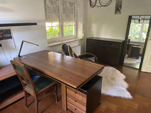 an office with a wooden desk and chairs at Willa 250 M z basenem, jacuzzi, ogrodem , tarasem oraz 2 hektary sadu , kominek i inne atrakcje in Buszkowice