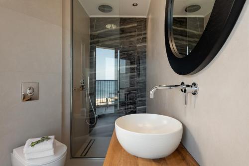 a bathroom with a white sink and a shower at Hotel Ideon in Rethymno Town