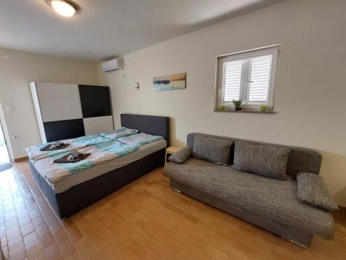 a bedroom with a bed and a couch at Studio apartment Aren in Porat