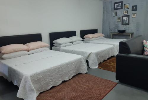 een kamer met 3 bedden en een bank bij ROOMMATE STUDIO in Kuah