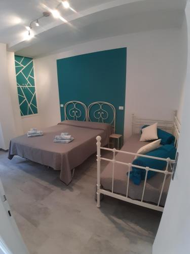 Cette chambre comprend 2 lits et un mur bleu. dans l'établissement Casa fontana rossa, à Arizzano