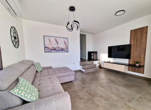 un soggiorno con divano e TV a schermo piatto di Villa Poseidon a Novalja (Novaglia)