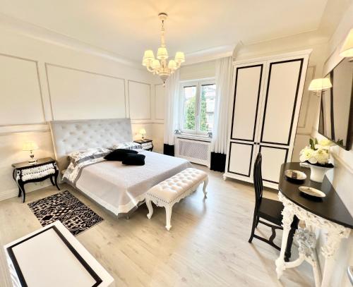 a white bedroom with a bed and a table and a desk at Ghibellines Apartments in Verona