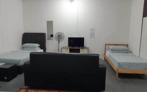a living room with two beds and a couch at ROOMMATE STUDIO in Kuah
