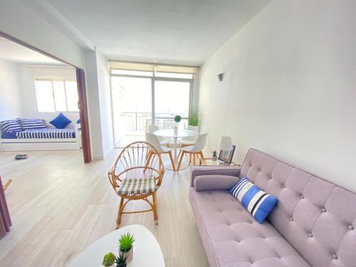 a living room with a purple couch and a table at NUEVO !!! Apartamento Peñíscola Playa con piscinas y tenis in Peñíscola
