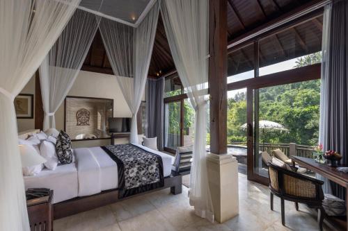 ein Schlafzimmer mit einem Bett und einem Balkon in der Unterkunft The Kayon Valley Resort in Ubud