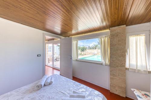 una camera da letto con un letto e una grande finestra di Dependance con piscina a Taurisano