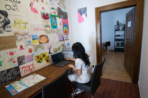 a woman sitting at a desk with a laptop computer at Women's Only Hostel - Female Only in Prague