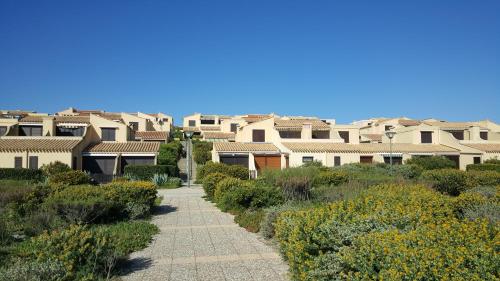 Une passerelle traversant une rangée de maisons dans l'établissement Maisonnette Port Leucate vue sur mer, à Port-Leucate