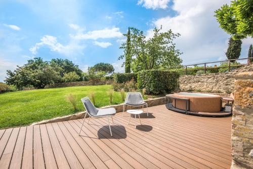 a wooden deck with two chairs and a hot tub at Brotes Appartamento Castagno in Sovicille