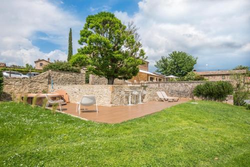 a backyard with a wooden deck and a stone wall at Brotes Appartamento Castagno in Sovicille