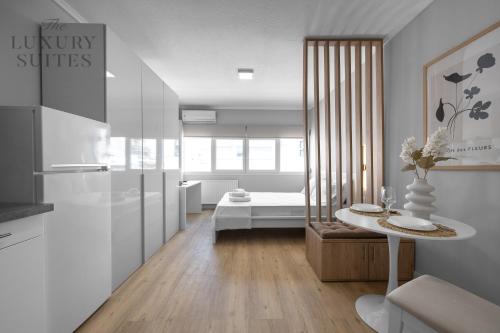 uma cozinha e sala de estar com uma mesa e uma cama em Nephele, The Luxury Suites em Tessalônica
