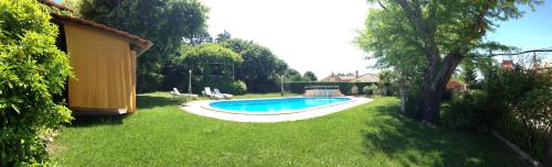a backyard with a swimming pool in the grass at Alegre - Bussaco Boutique Hotel in Luso