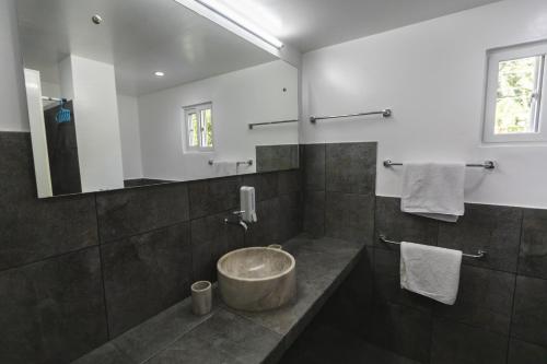 a bathroom with a large mirror and a sink at The Three P Beach Resort & Dive Center in Romblon