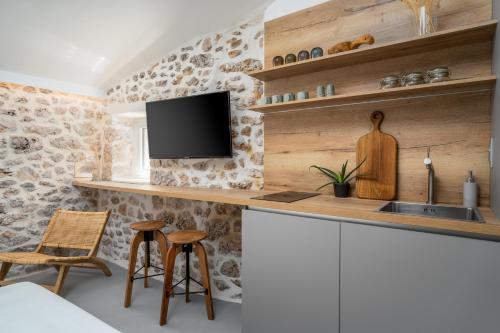 a kitchen with a sink and a tv on a wall at Murvica resport in Murvica